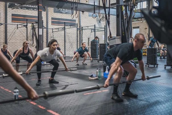 People working out with barbell on a CrossFit class